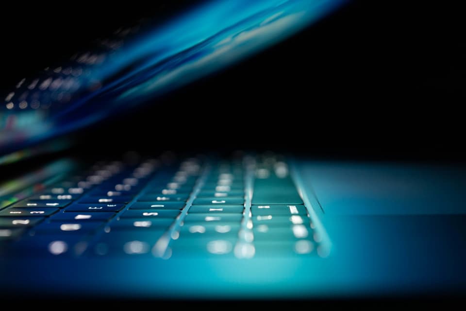 Data security — backlit laptop keyboard in low light, secure technology